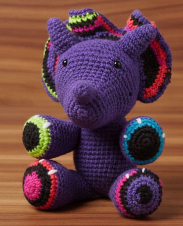 Crocheted purple dino toy with colorful accents on a wooden surface