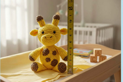 Yellow crocheted giraffe toy next to a measuring tape on a wooden surface.