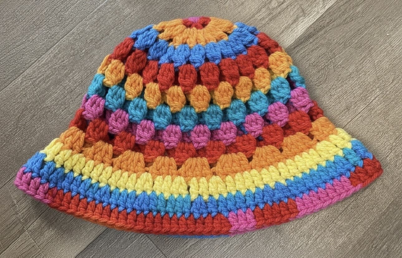 Colorful crocheted hat on a wooden surface