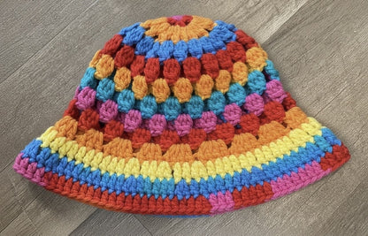 Colorful crocheted hat on a wooden surface