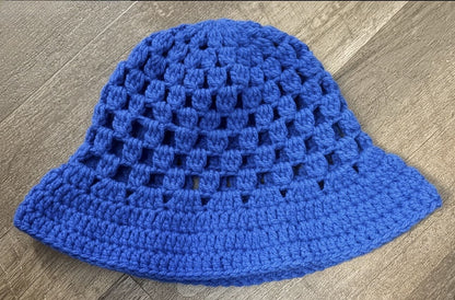 Blue crochet hat on a wooden surface