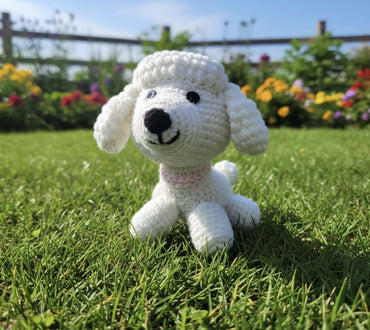 White crochet dog toy on grass with a garden background