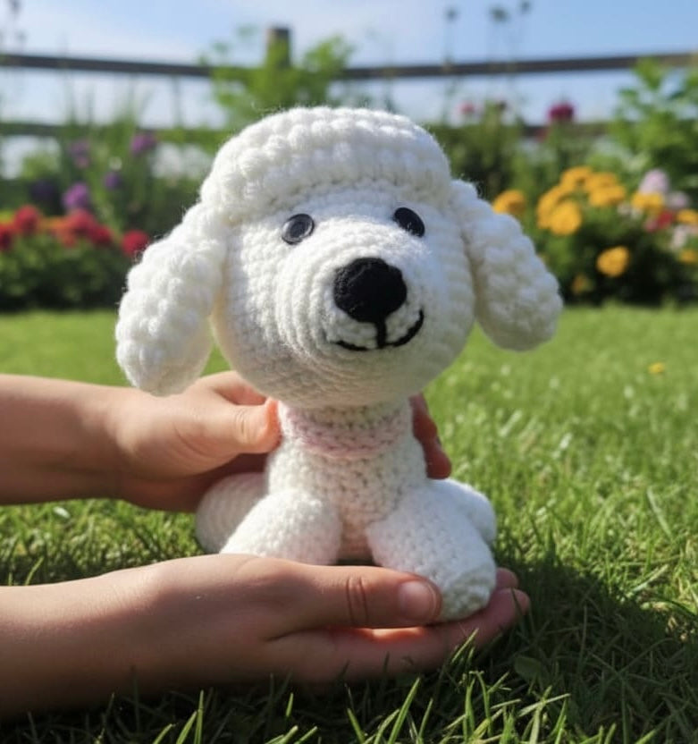 White crochet dog toy held by a person in a garden with flowers and grass.